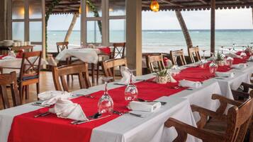 A restaurant with tables set for dining, overlooking the sea.