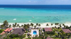 A resort with a swimming pool, beachfront view, and several boats in the water. - Mandarin Resort Zanzibar (Kizimkazi)