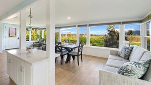 A spacious living area with a large window offering a view of a lush landscape.