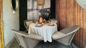A dining area with wicker chairs and a round table, a hanging light fixture, and a wall-mounted mirror. - CASA YON pet friendly, Netflix, Booking,free parking, high speed wifi (Cuautitlán Izcalli)