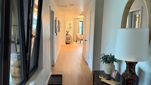 A hallway with wooden flooring, a dark wooden table with a lamp, and a potted plant. - Parkside Paradise near Montana State University (Bozeman)