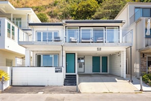 A two-story residential building with a balcony, a garage, and a driveway. - 1960's Rio Del Mar Beach House - Stunning Views! (Aptos)