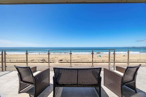 A terrace with wicker furniture overlooking a beach. - 1960's Rio Del Mar Beach House - Stunning Views! (Aptos)