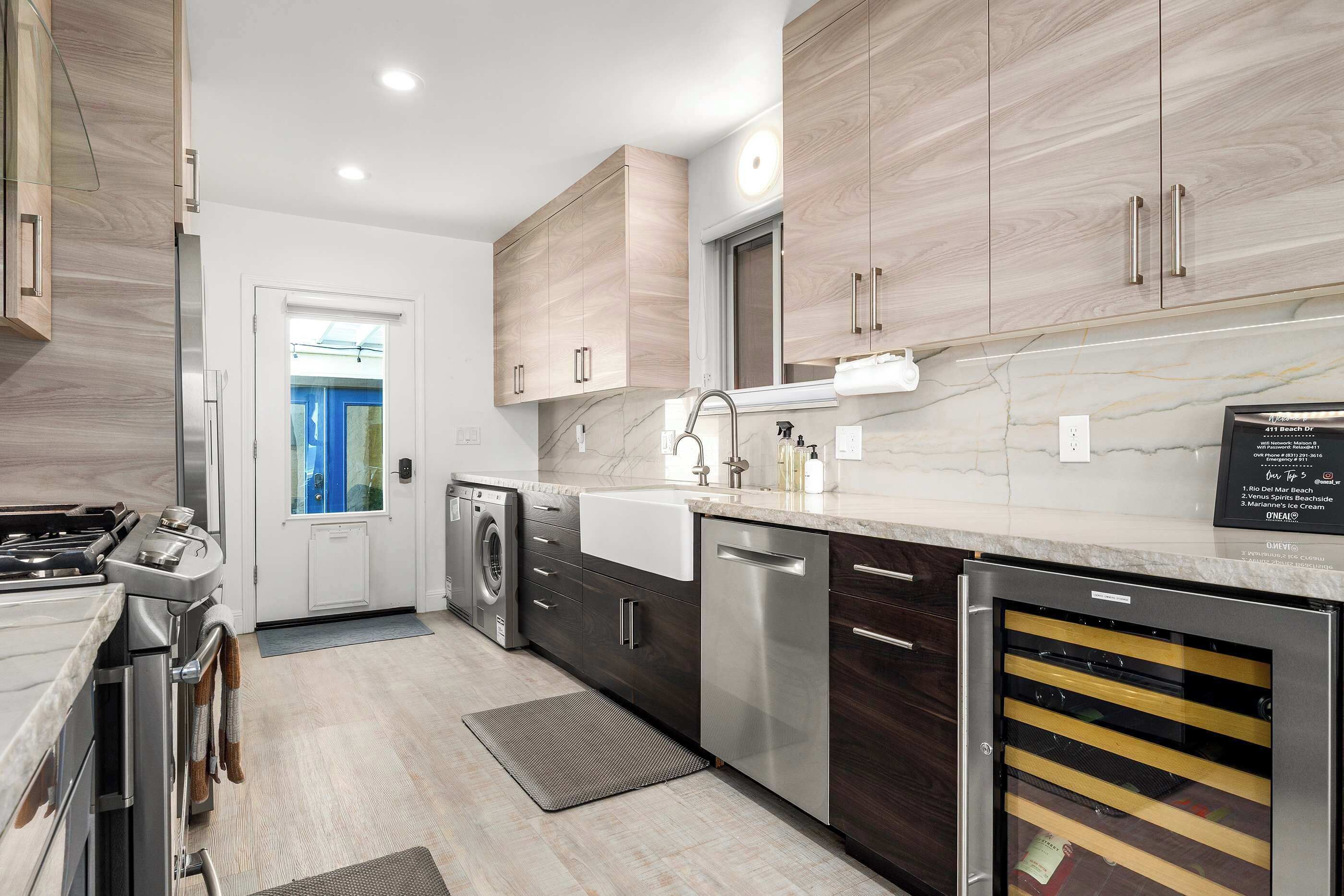 A modern kitchen with stainless steel appliances, wooden cabinets, and a marble countertop.