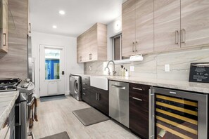 Una cocina moderna con electrodomésticos de acero inoxidable, armarios de madera y encimera de mármol.