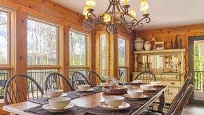 A wooden dining room with a long table set for six, surrounded by chairs. - Luxury Mountain Retreat with Hot Tub and Views (Telluride)