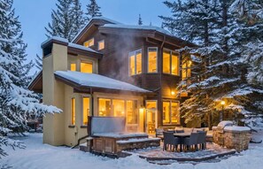 A multi-level wooden house with a covered patio area, surrounded by snow-covered trees. - Cascade Village 4BR | Hot Tub + Shuttle Access (Vail)