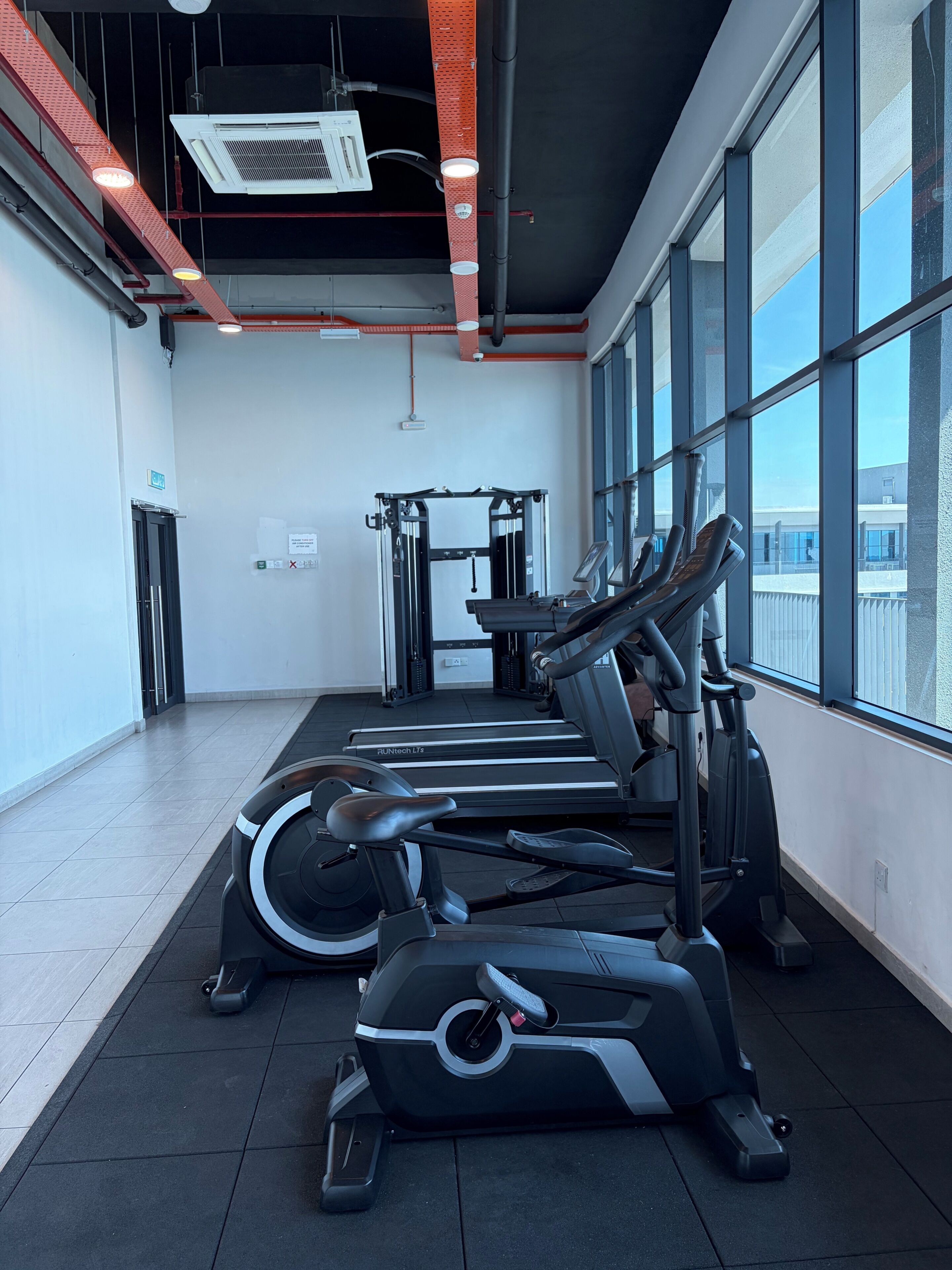Uma academia com esteiras, elípticos e máquinas de musculação.