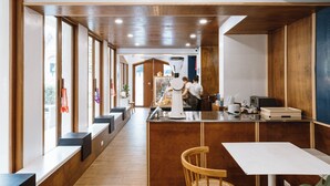Un interior moderno con una encimera larga, detalles de madera y ventanas amplias.