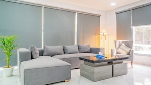 Un soggiorno moderno con un divano modulare grigio, un tavolino in legno e una lampada da terra.