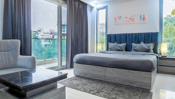 Una camera da letto moderna con un letto grande, un divano e vista sulla città.