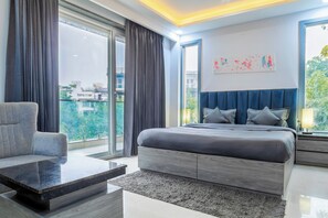 Une chambre moderne avec un grand lit, un canapé et une vue sur la ville.