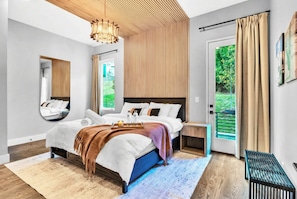 Una camera da letto moderna con un letto grande, un comodino, uno specchio e vista sull'esterno.