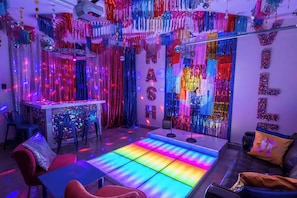 A room with a colorful light floor, a bar area, and festive decorations.
