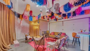 A room with a sofa, chairs, a small table, and a bar area with drinks.