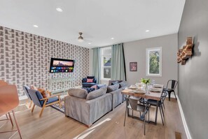 Sectional sofa, dining table, and open layout keep the whole group together for movies, meals, or pregame strategy