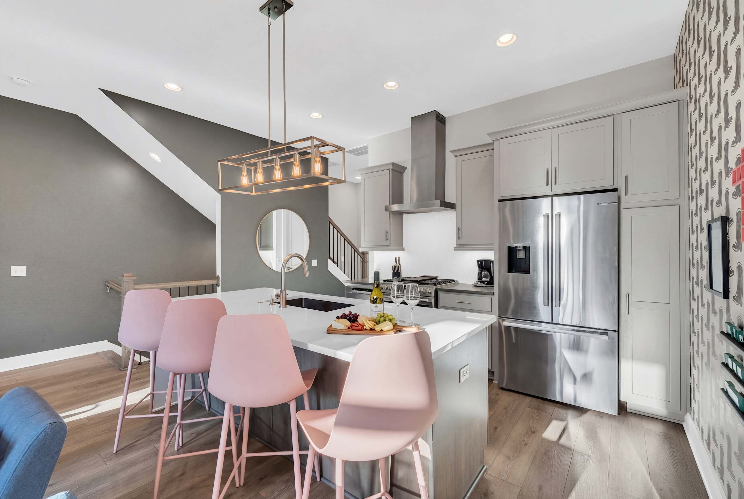 A modern kitchen with a central island, stainless steel appliances, and a unique ceiling light fixture.