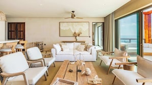 A modern living room with a white sofa, wooden coffee table, and a ceiling fan. - Artila PH: Seaview Oasis with Private Terrace and Direct Access to the Beach (Isla Mujeres)