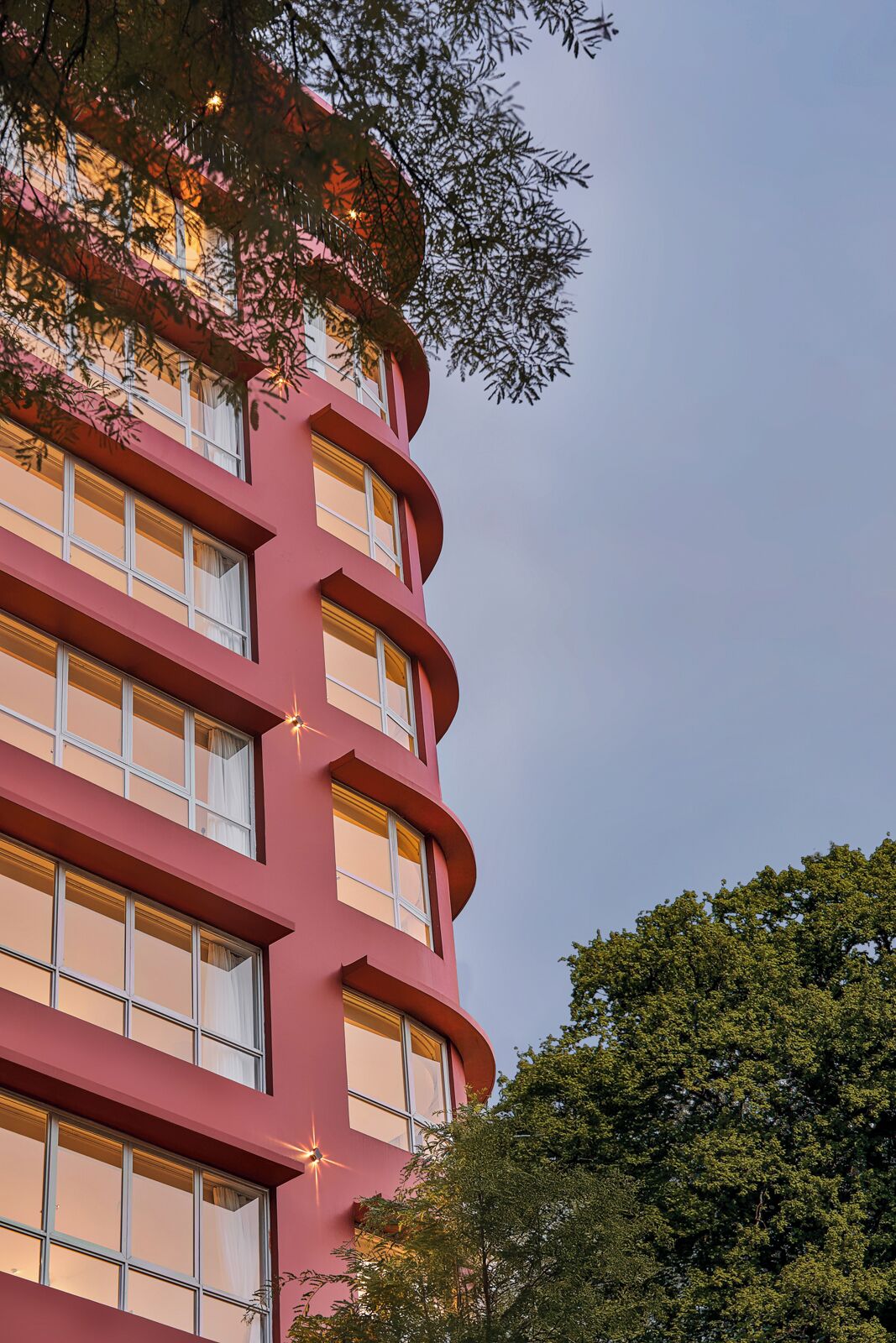 Ein mehrgeschossiges Gebäude mit einer geschwungenen Fassade und großen Fenstern.