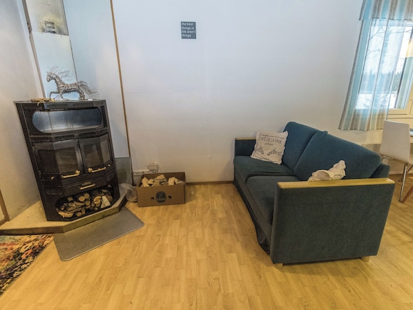 A living room with a fireplace, a sofa, and a small table.