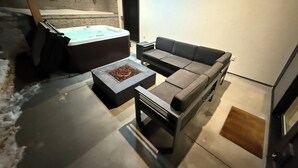 Un salon moderne avec un canapé, une table basse et une cheminée.