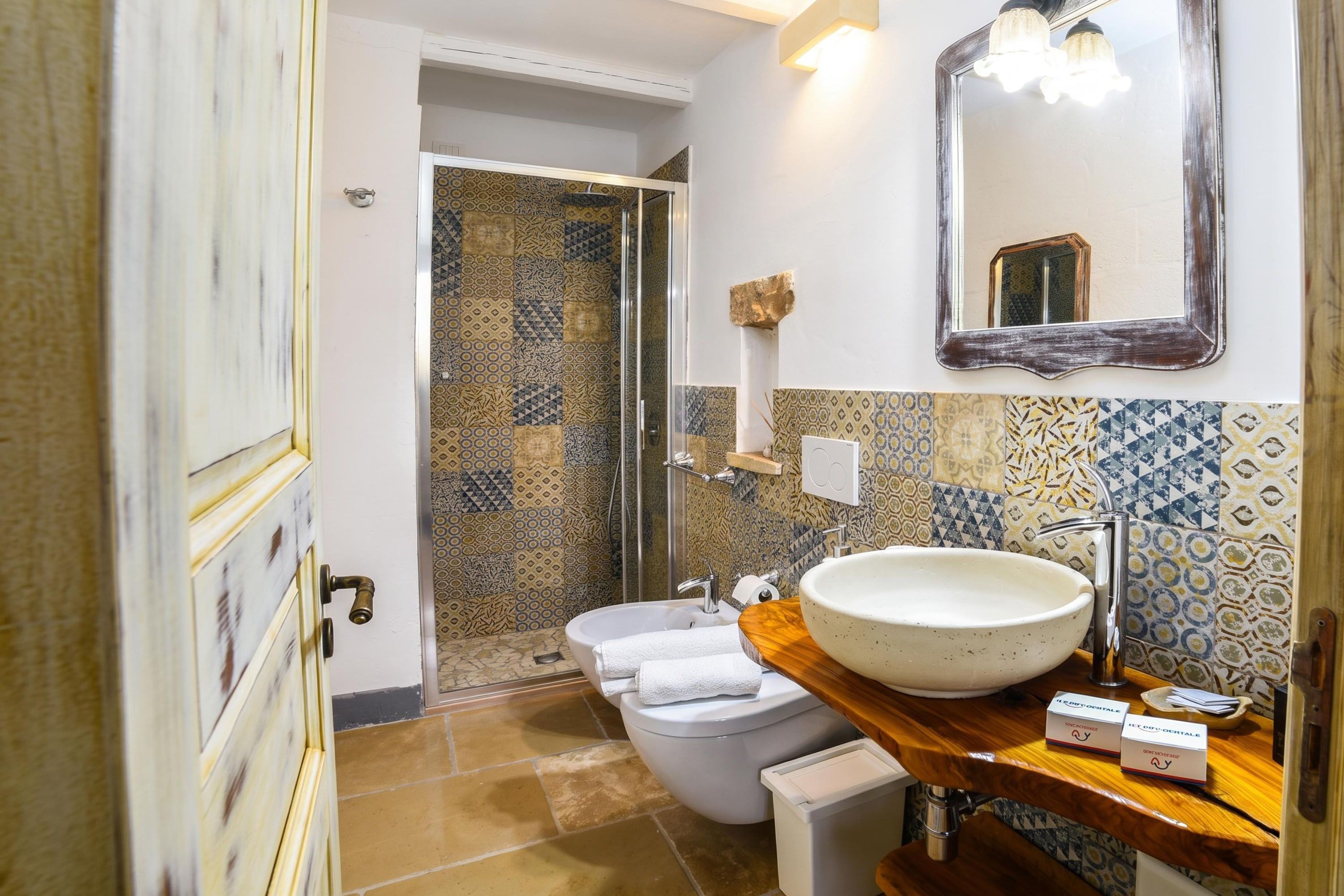A bathroom with a large sink, toilet, and shower area.