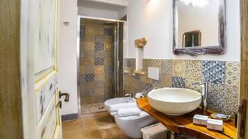 A bathroom with a large sink, toilet, and shower area.