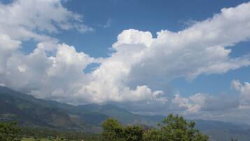 Paisaje montañoso con cielo despejado y nubes dispersas.