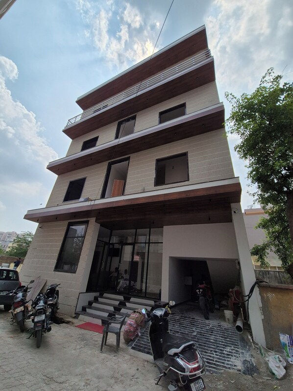 A multi-story building with a flat roof and large windows. - OnlyStay Surbhi Dham (Vrindavan)