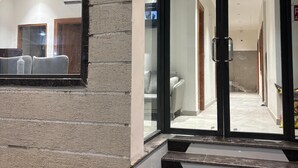 A modern hotel entrance with a glass door, a staircase, and a ceiling fan. - OnlyStay Surbhi Dham (Vrindavan)