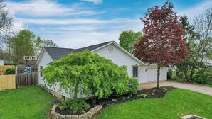 A single-story house with a well-maintained lawn and a large tree with red leaves. - Quiet Ranch Retreat for Work Crews & Families Johnstown, OH (Johnstown)