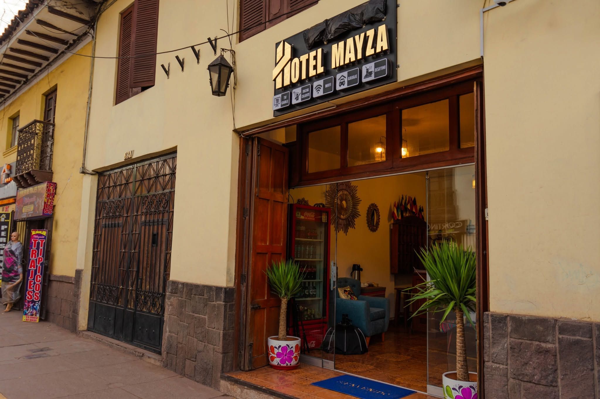 A hotel entrance with a sign indicating amenities like TV, cable, WiFi, and a garage.