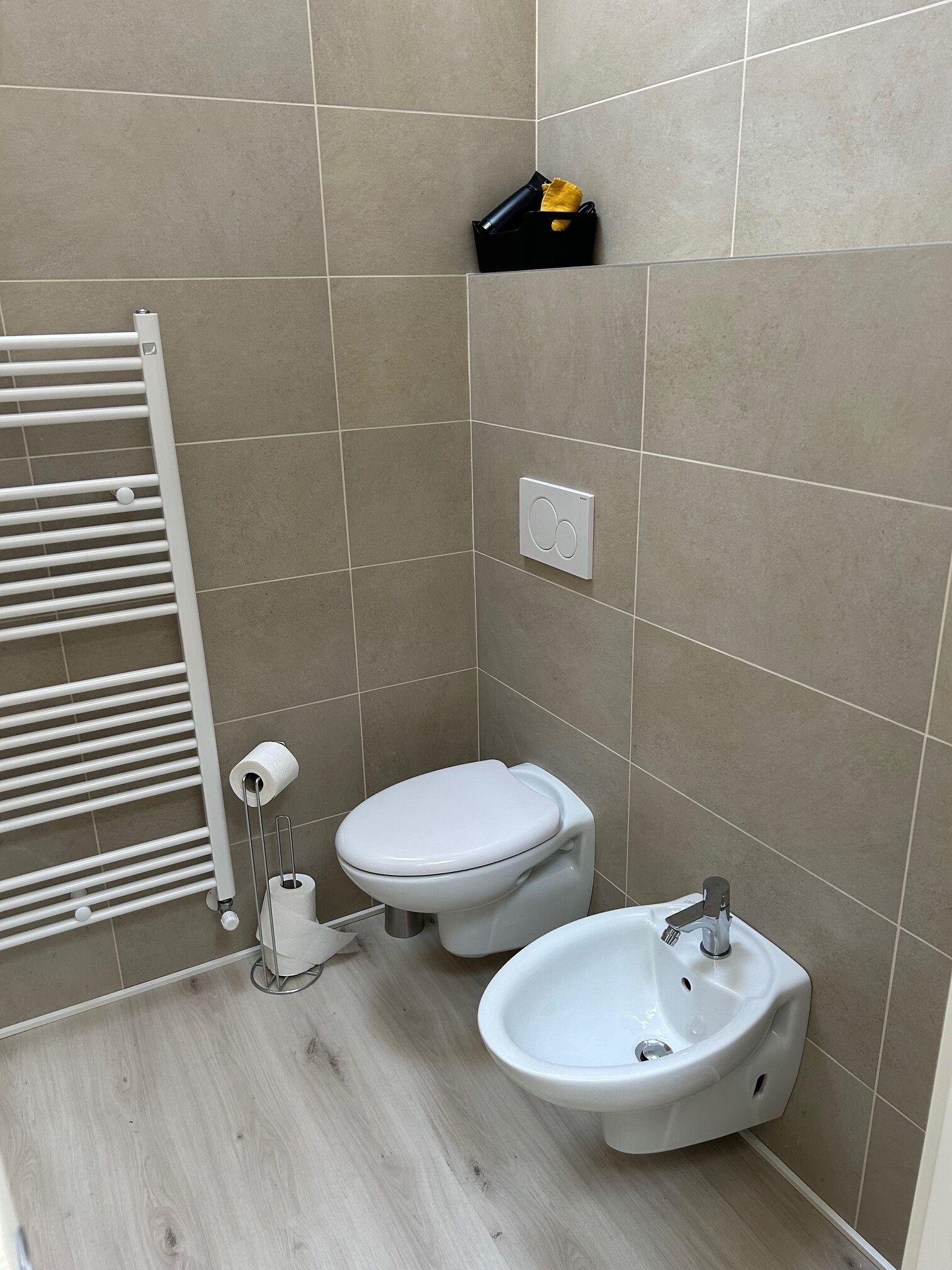 A small bathroom with a toilet, bidet, and sink.