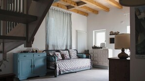 Une chambre à coucher avec un lit, une commode, une lampe et un escalier.