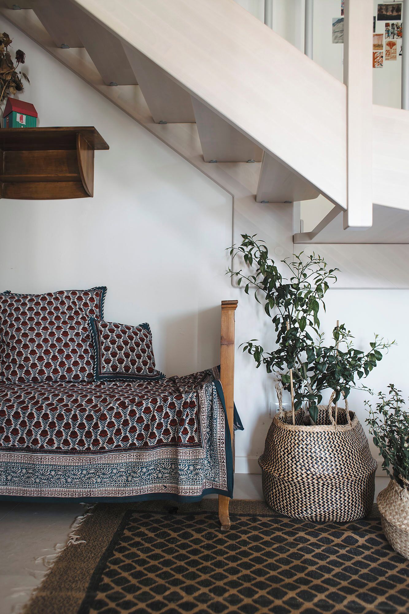 A modern living room with a patterned sofa, a wooden bench, and a large woven basket.