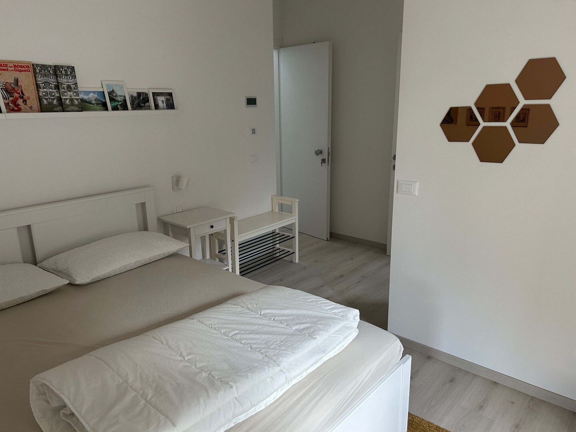 Ein modernes Schlafzimmer mit einem großen Bett, einem kleinen Schreibtisch und einem Kleiderschrank.