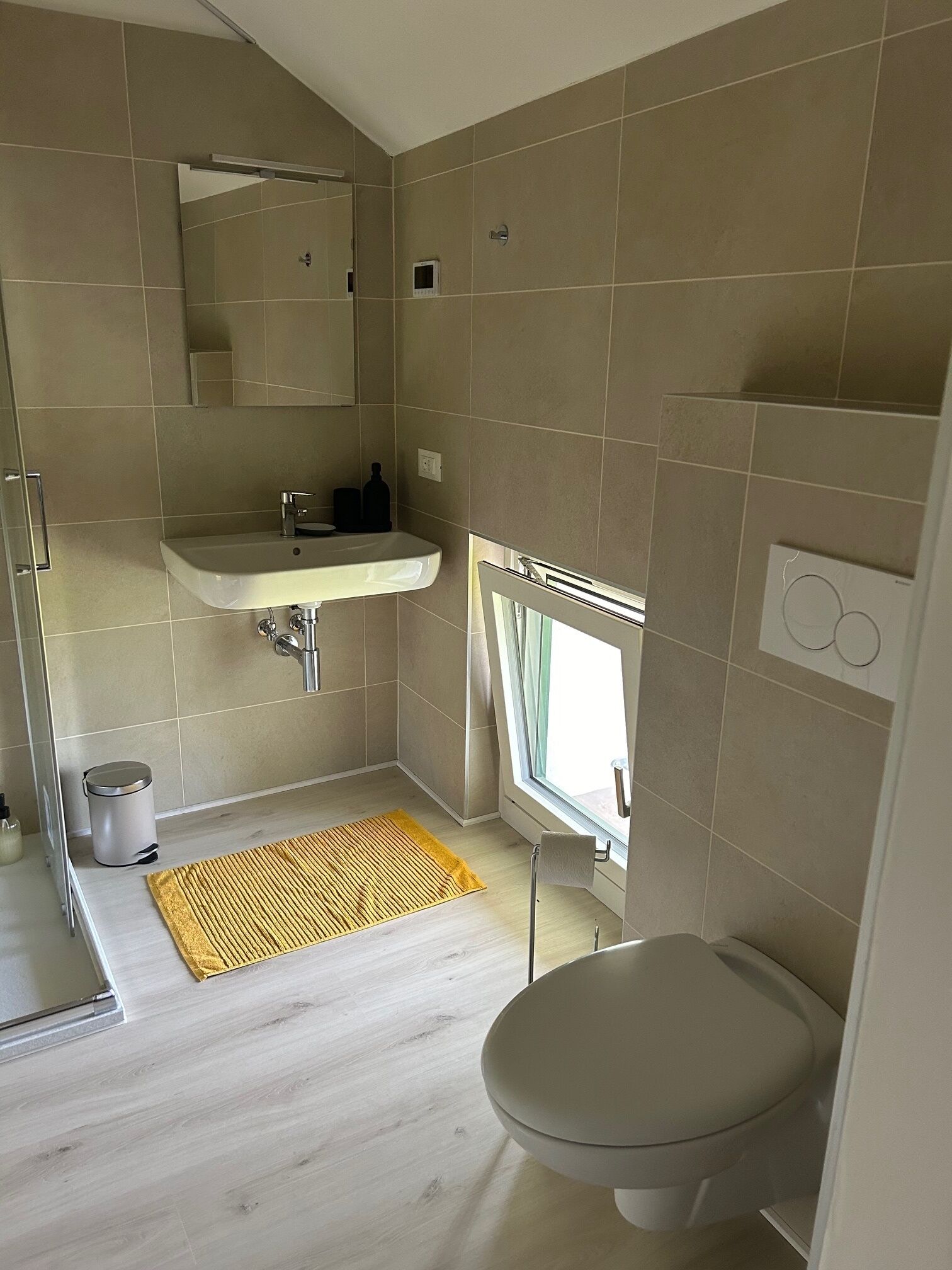 A bathroom with a toilet, sink, and shower.
