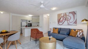 Ein modernes Wohnzimmer mit Sofa, Couchtisch und Essbereich.