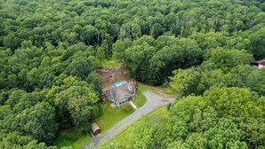 Una casa grande rodeada de un bosque frondoso.