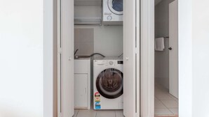 A compact laundry room with a front-loading washing machine and a dryer.