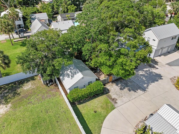 An aerial view of a residential area with houses, trees, and a clear sky.