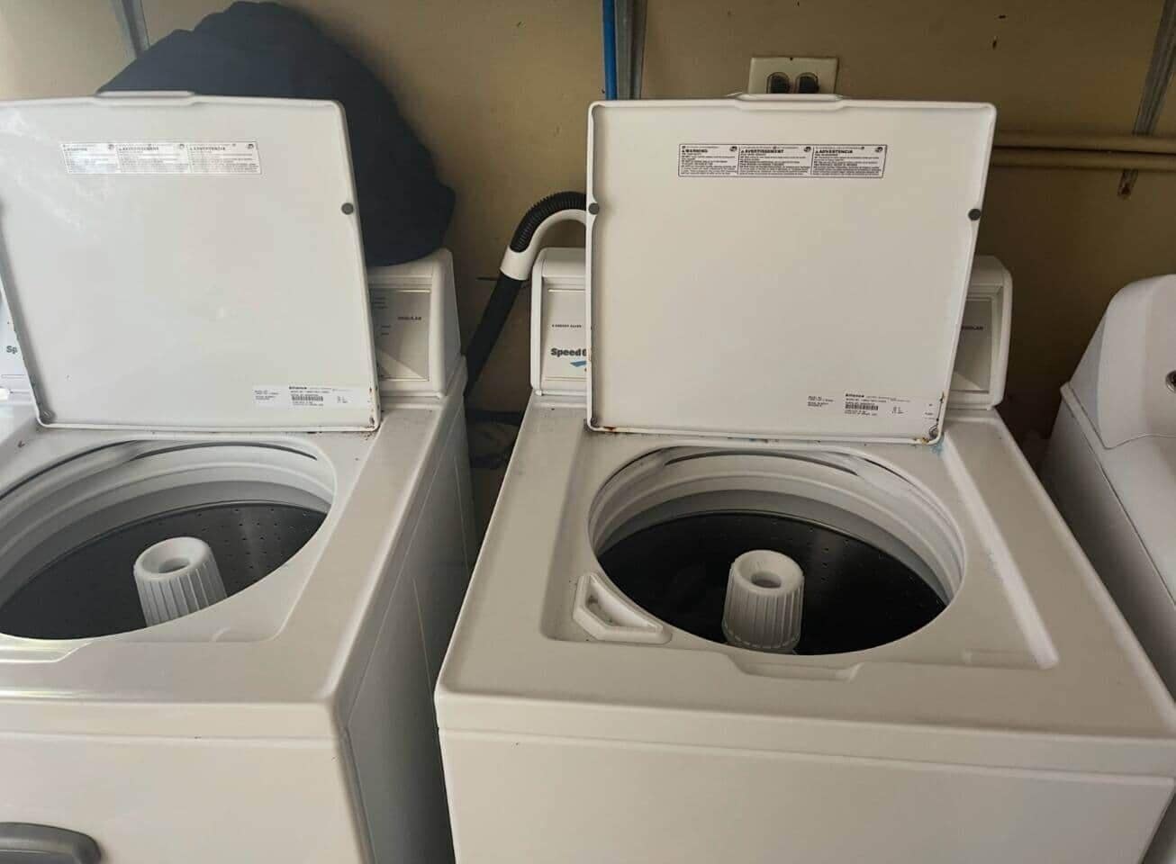 Two front-loading washing machines in a laundry area.