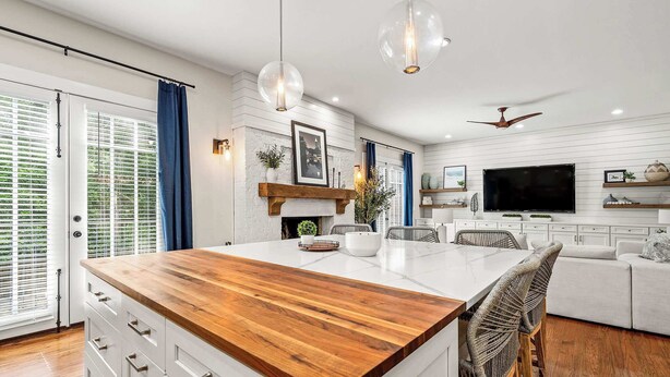 A modern kitchen with a central island, white cabinetry, and a wooden countertop. - 10 Mins to Mercedes-Benz Stadium | Dog Friendly (Atlanta)