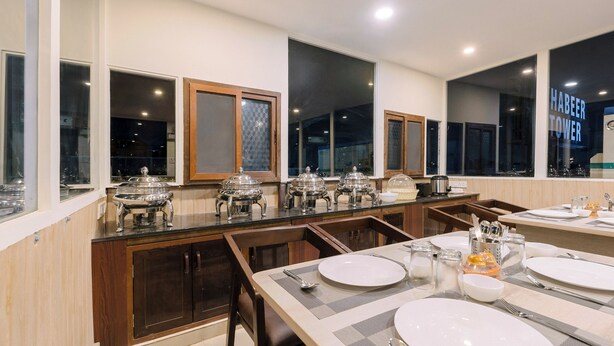 Zona pranzo moderna con buffet, mobili in legno e ampie finestre.