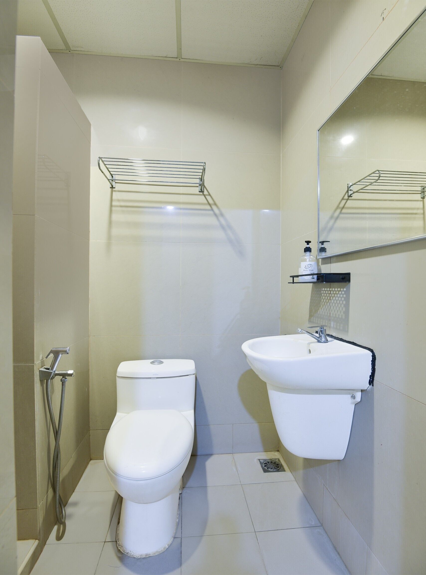 Un baño con inodoro, lavamanos, ducha y espejo.