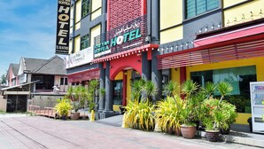 A hotel with a prominent sign, large potted plants, and a red awning. - Hotel O Rayyan Soffea Managed by Oravel (Kota Bharu)