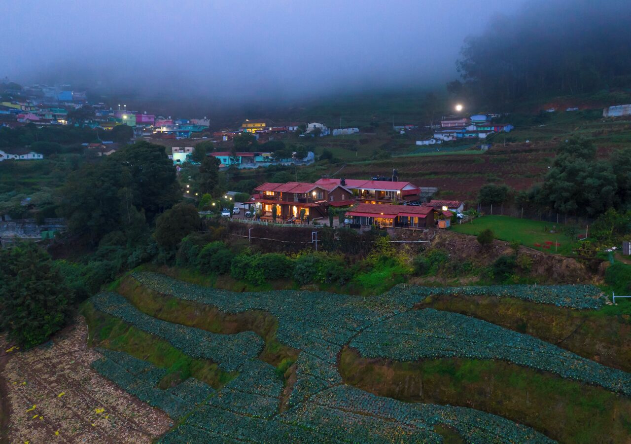 A large house with multiple rooms, surrounded by terraced fields.