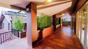 A corridor with tiled flooring, a glass door on the right, and a potted plant on the left. - Silent Valley Farmstead by VOYE HOMES (Ooty)