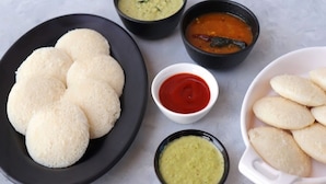 A plate of idlis with three different chutneys and a bowl of sambar. - Silent Valley Farmstead by VOYE HOMES (Ooty)