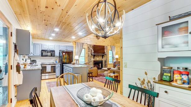 A spacious kitchen with modern appliances, a dining area with a wooden table, and a cozy living space with a fireplace. - Luxury Blue Ridge Cabin: Hot Tub & 5 Min to Town (Blue Ridge)